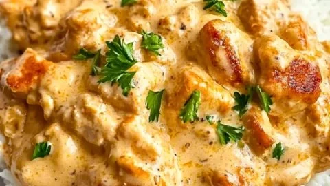 Creamy smothered chicken served with rice on a plate