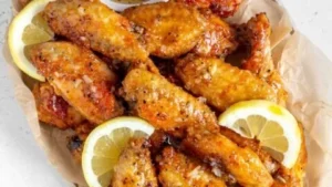 Plate of honey lemon pepper wings garnished with herbs