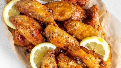 Plate of honey lemon pepper wings garnished with herbs
